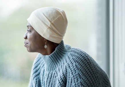 Woman with cancer looks out the window