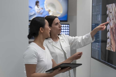 Two radiologists review test results together on a screen in a hospital