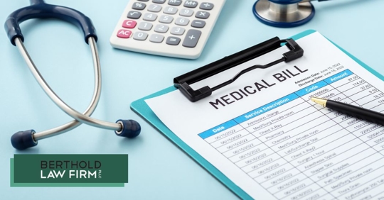 closeup of a medical bill, calculator, and stethoscope